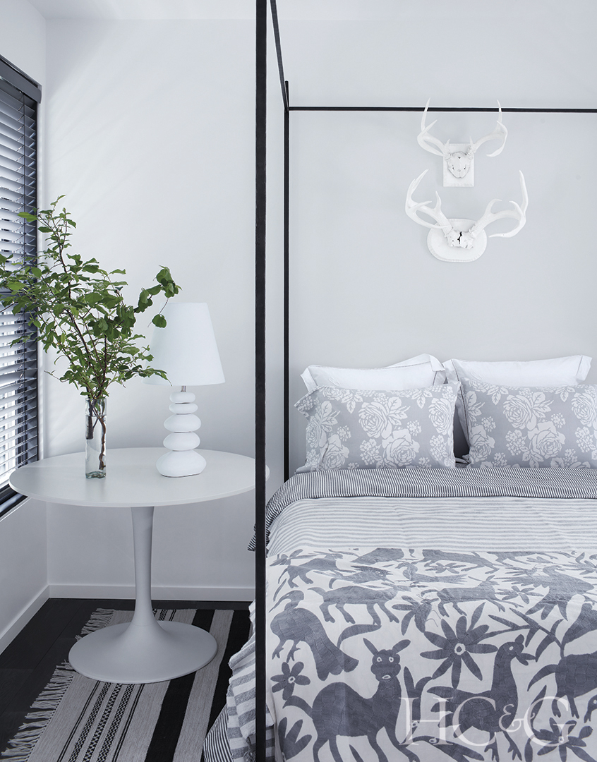 embroidered coverlet and iron bed frame in guest room