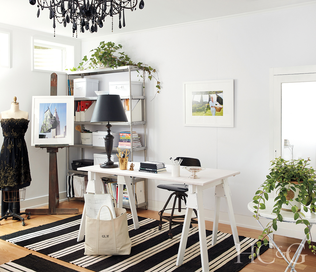 office rug, white desk, black chandelier, and plant decor