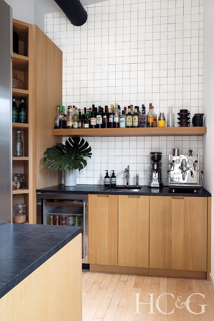 wood cabinetry, refrigerator, and wine refrigerator; white backsplash tile