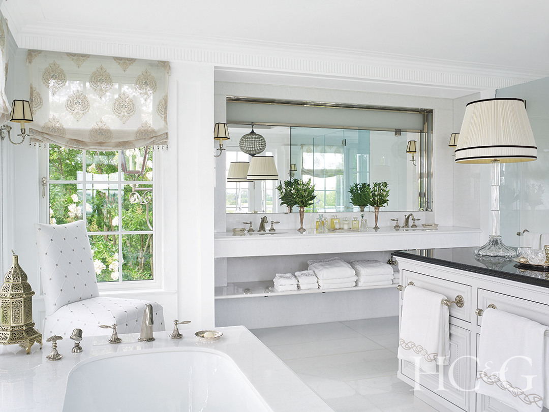 master bathroom with mirror, sinks, tub, and fittings