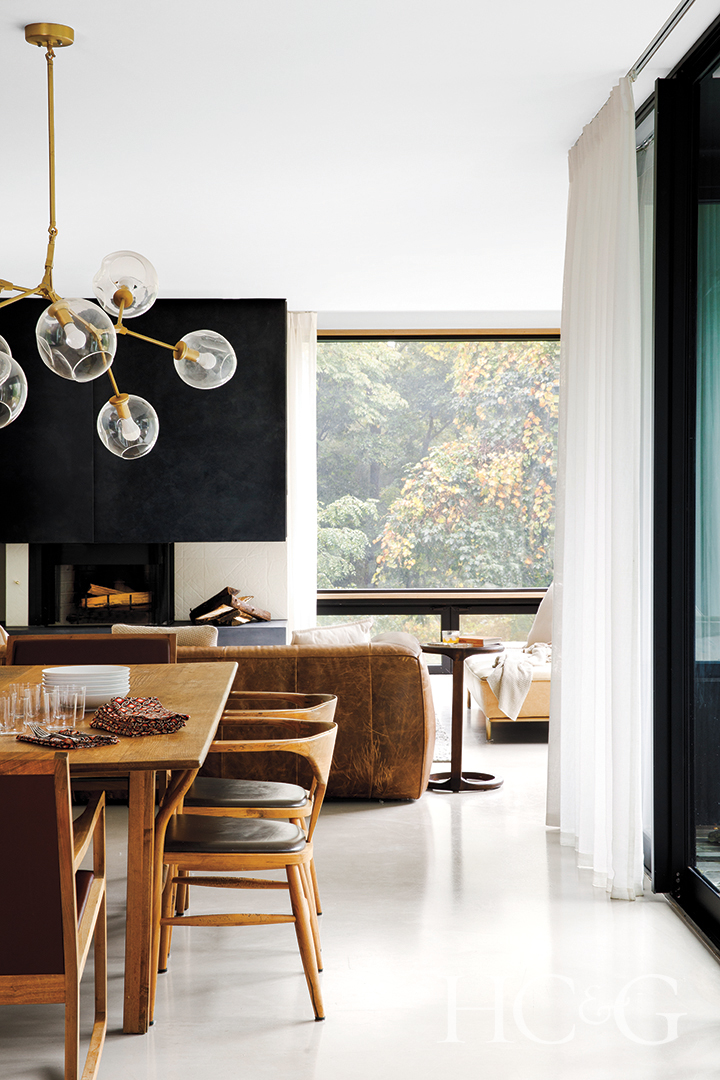 wooden dining table and chairs and geometric light fixture
