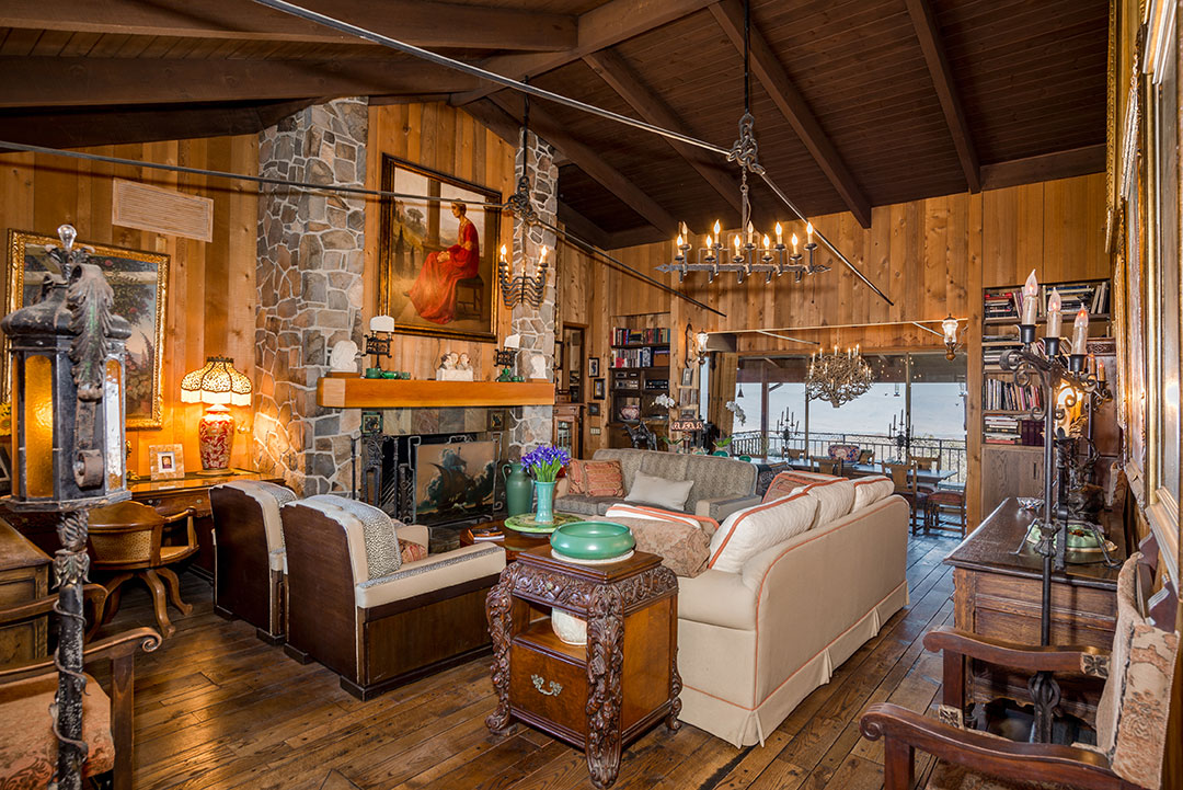 Soaring Wood Beamed Ceilings And Stone Fireplace In Living Room Of Main House