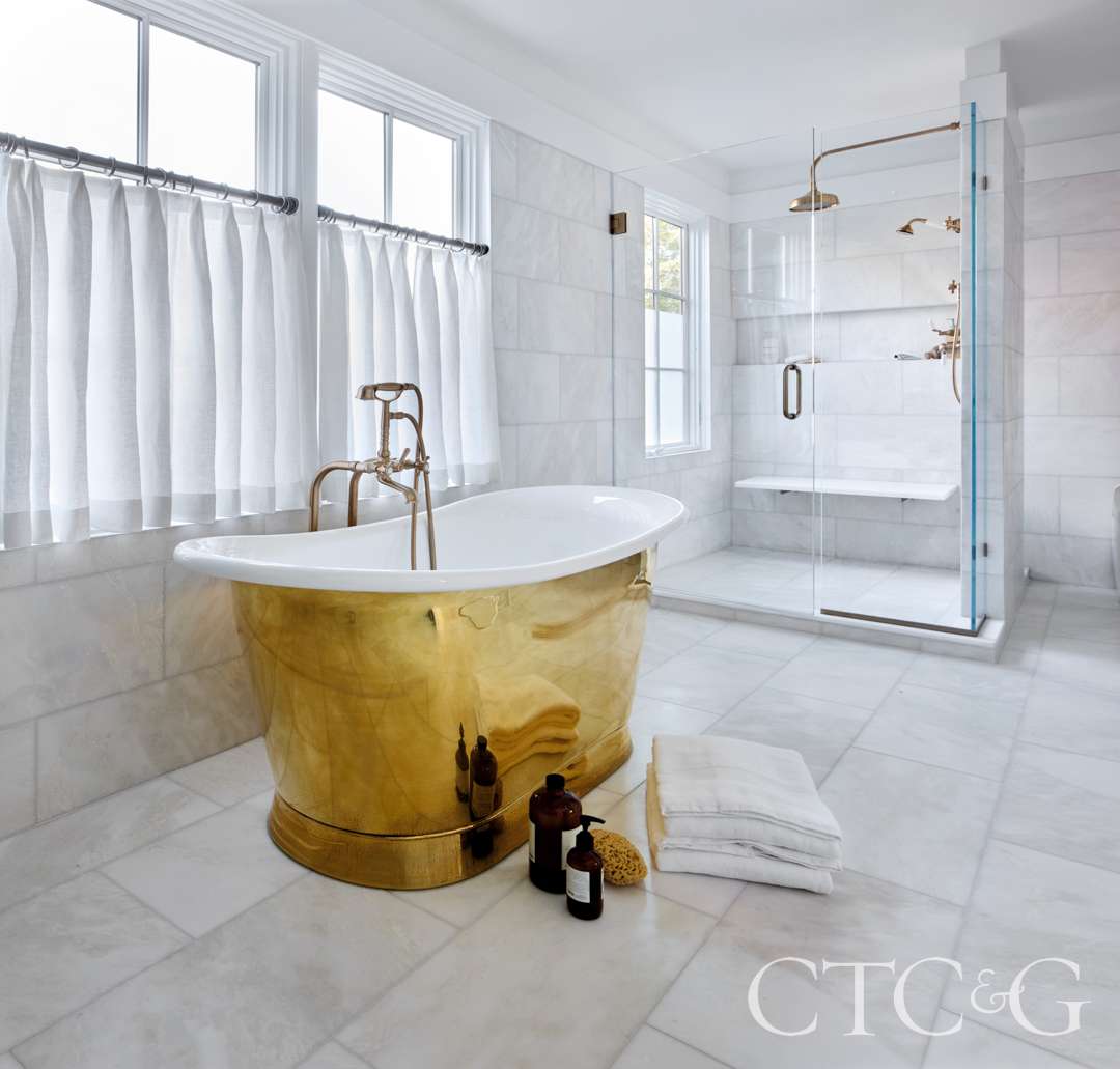 Grand centerpiece in primary bathroom is the brass bathtub