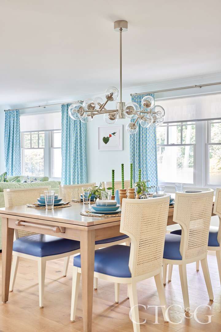 Small hummingbird artwork hangs across the dining room table