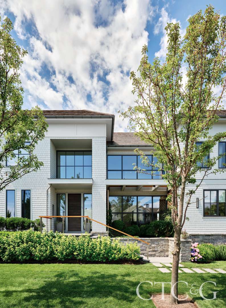 Contemporary home entrance framed by pear trees and boxwoods