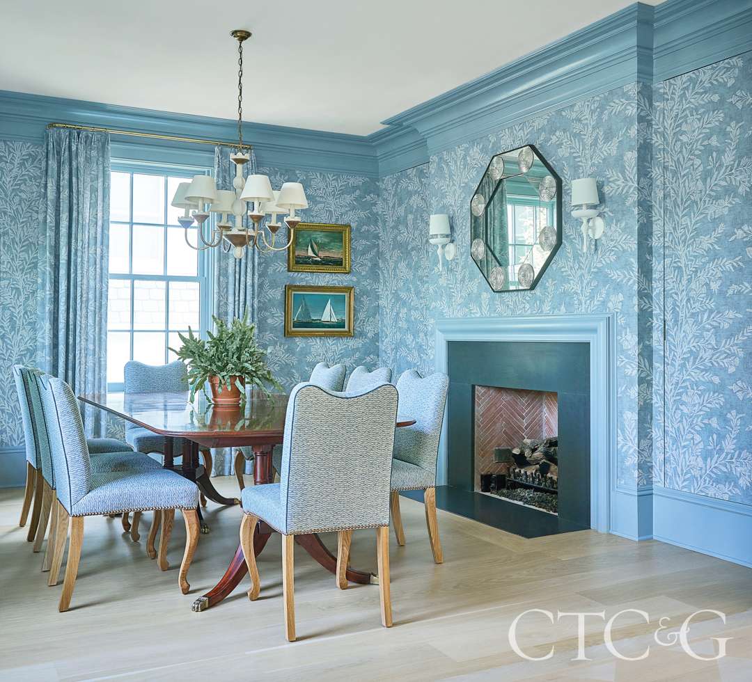 Flower patterned draperies and wallpaper decorate the dining room