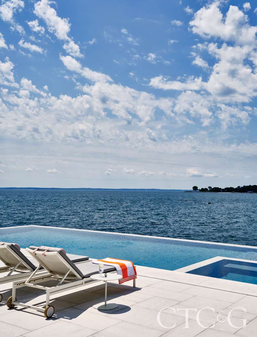 Chaise lounges alongside an oceanfront pool