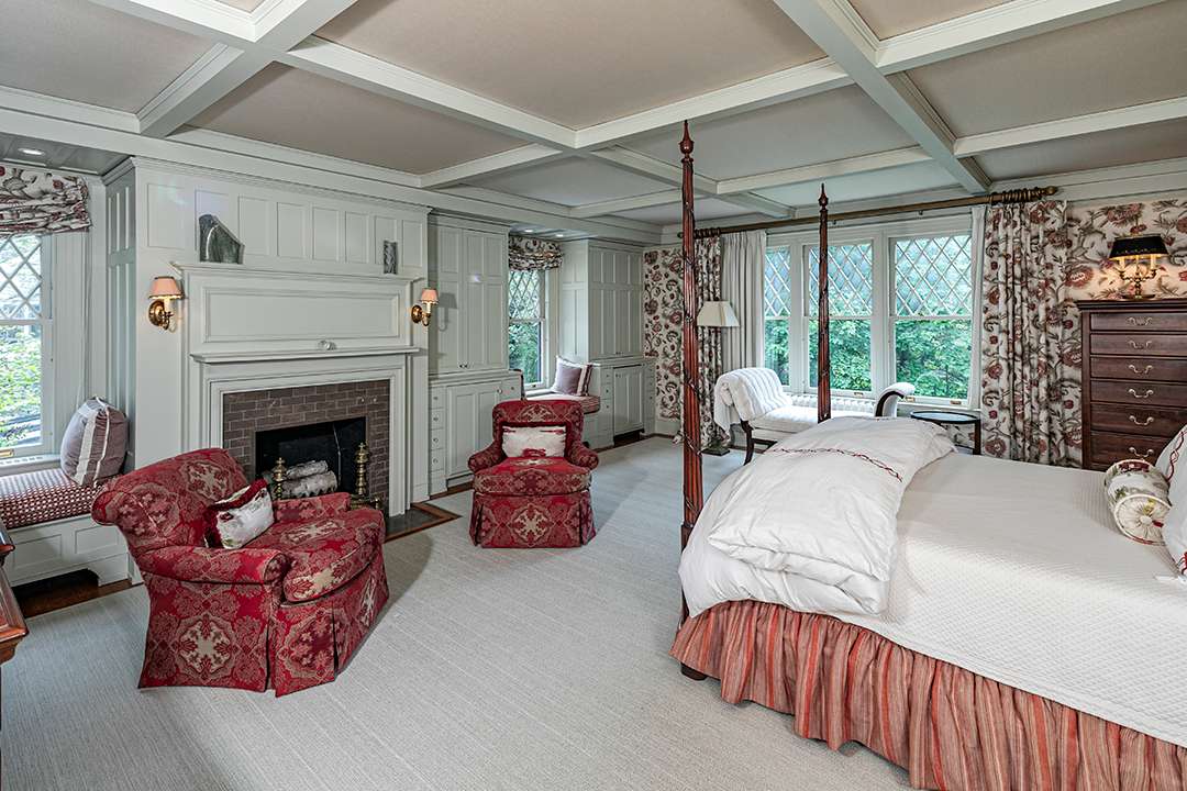 Historic bedroom with red chairs and a loveseat