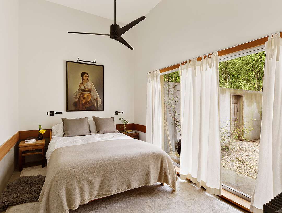 Sophisticated bedroom with portrait hung above bed
