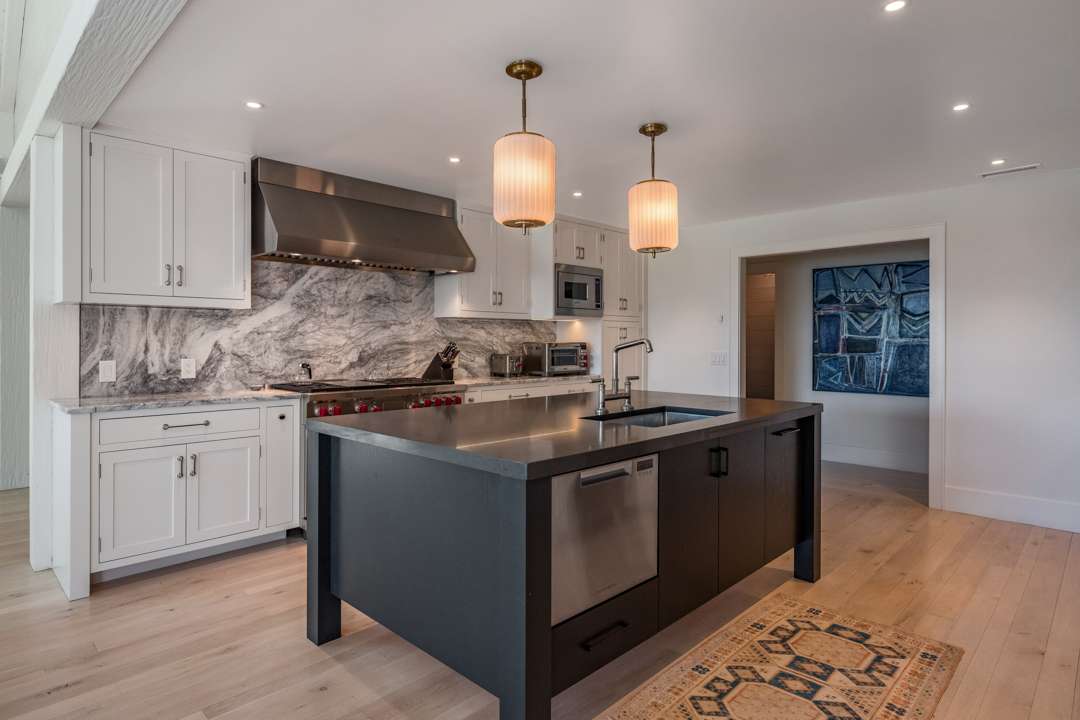 Kitchen with black island and wood floors