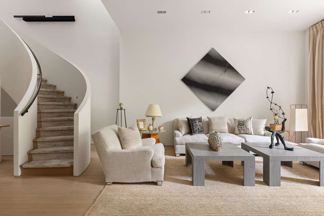 Neutral living room with fun art and staircase