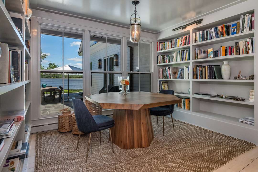Breakfast nook with wood table, blue chairs, and bookshelves