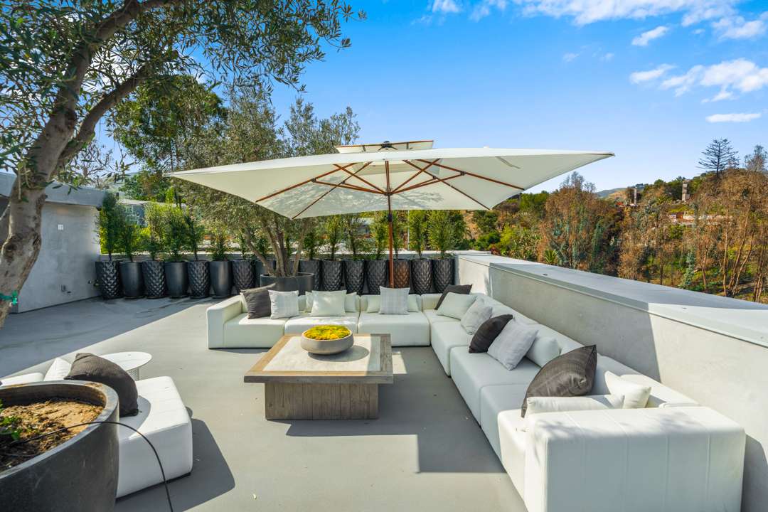 White outdoor wrap around couch and umbrella