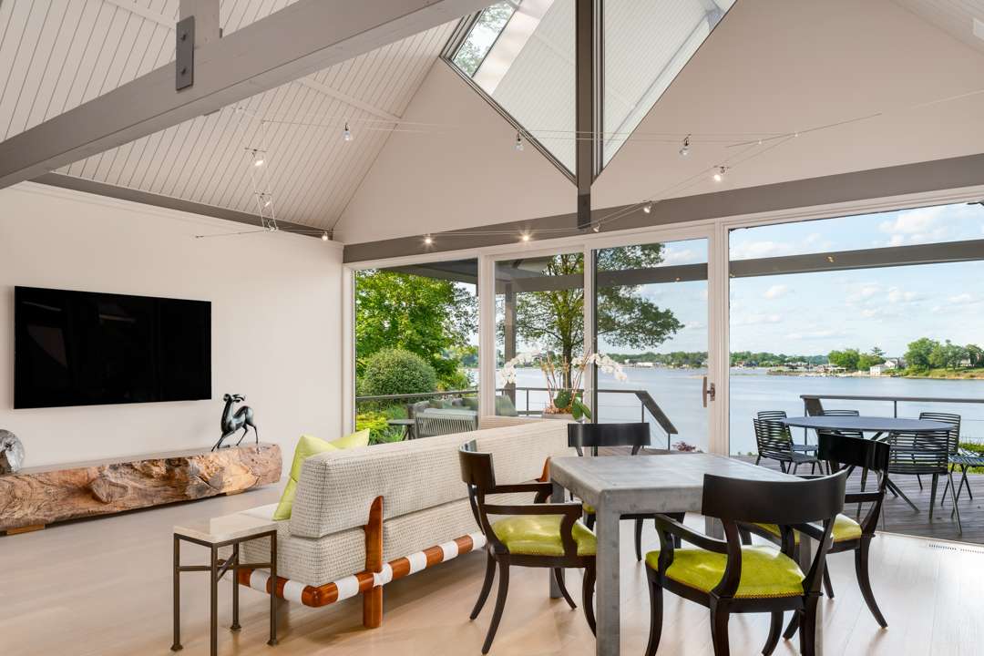 Living room and dining table with green accents overlooking water