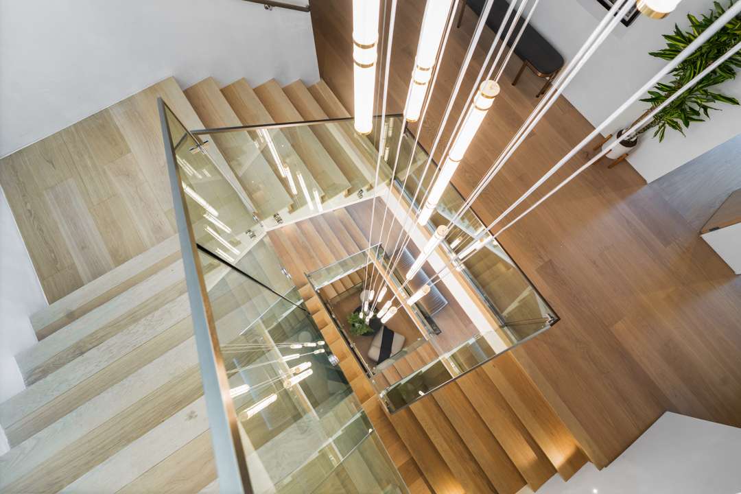 Wood staircase with cylinder hanging chandelier