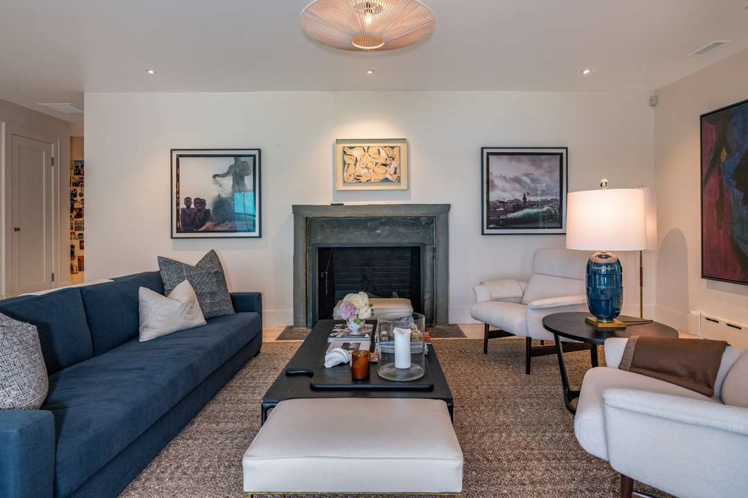 Living room with blue couch and white lounge chairs