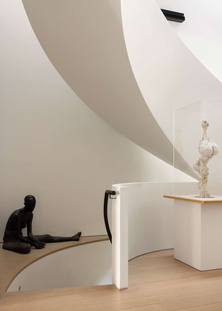 White spiral staircase with black and white sculptures