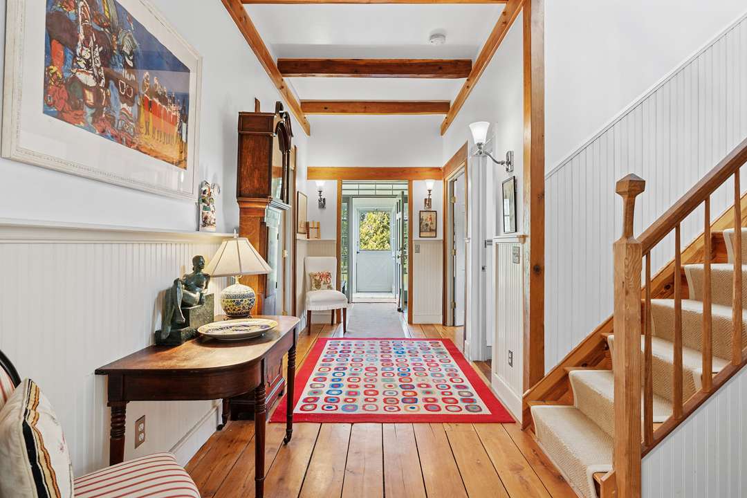Foyer with wood furniture and red and blue funky carpet