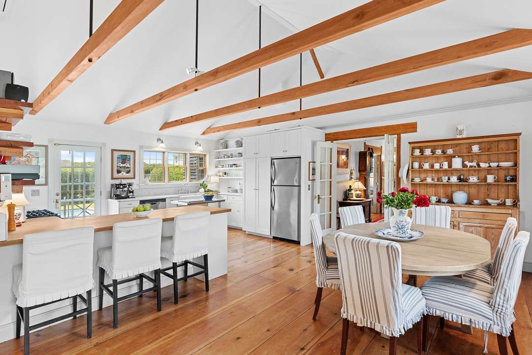 White kitchen and dining area with wood floors and blue accents