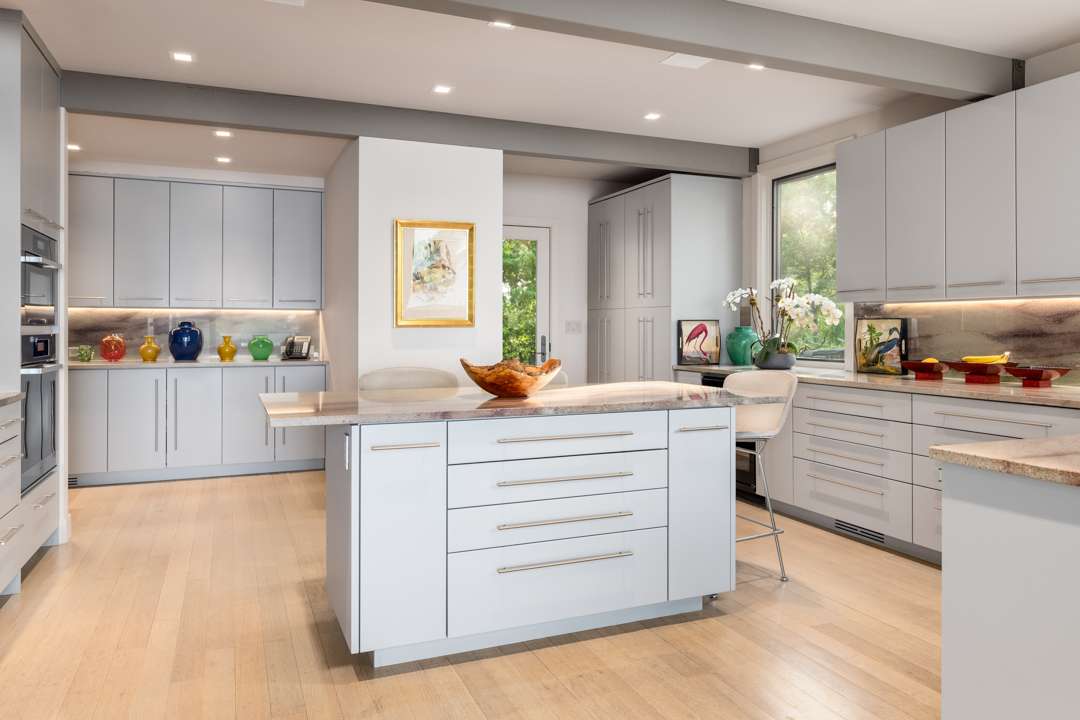 White and gray kitchen with marble counters and island