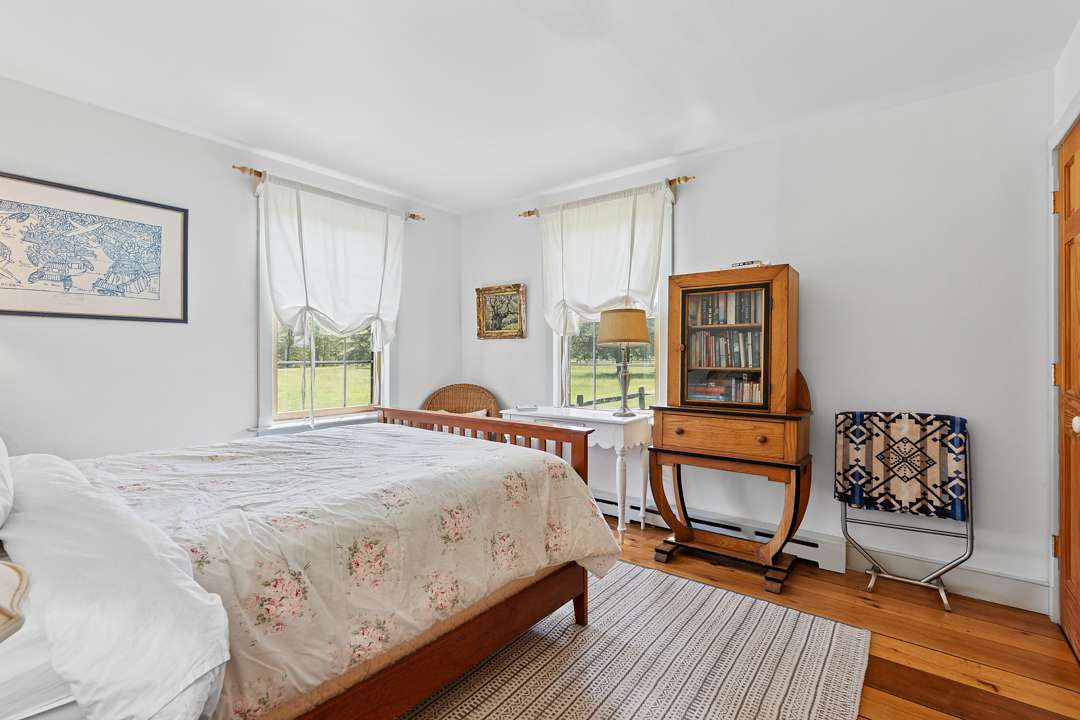 Bedroom with floral bedding and wood furniture