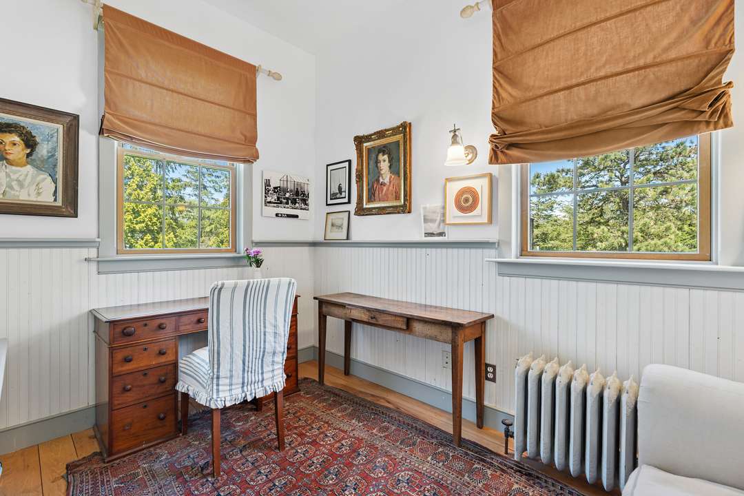 Office space with wood furniture and white walls with art