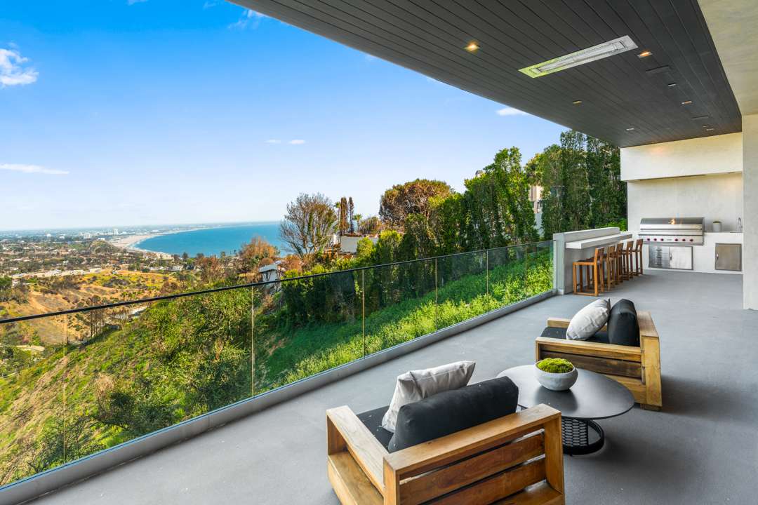 Deck with outdoor seating and grill area overlooking Pacific Palisades and ocean