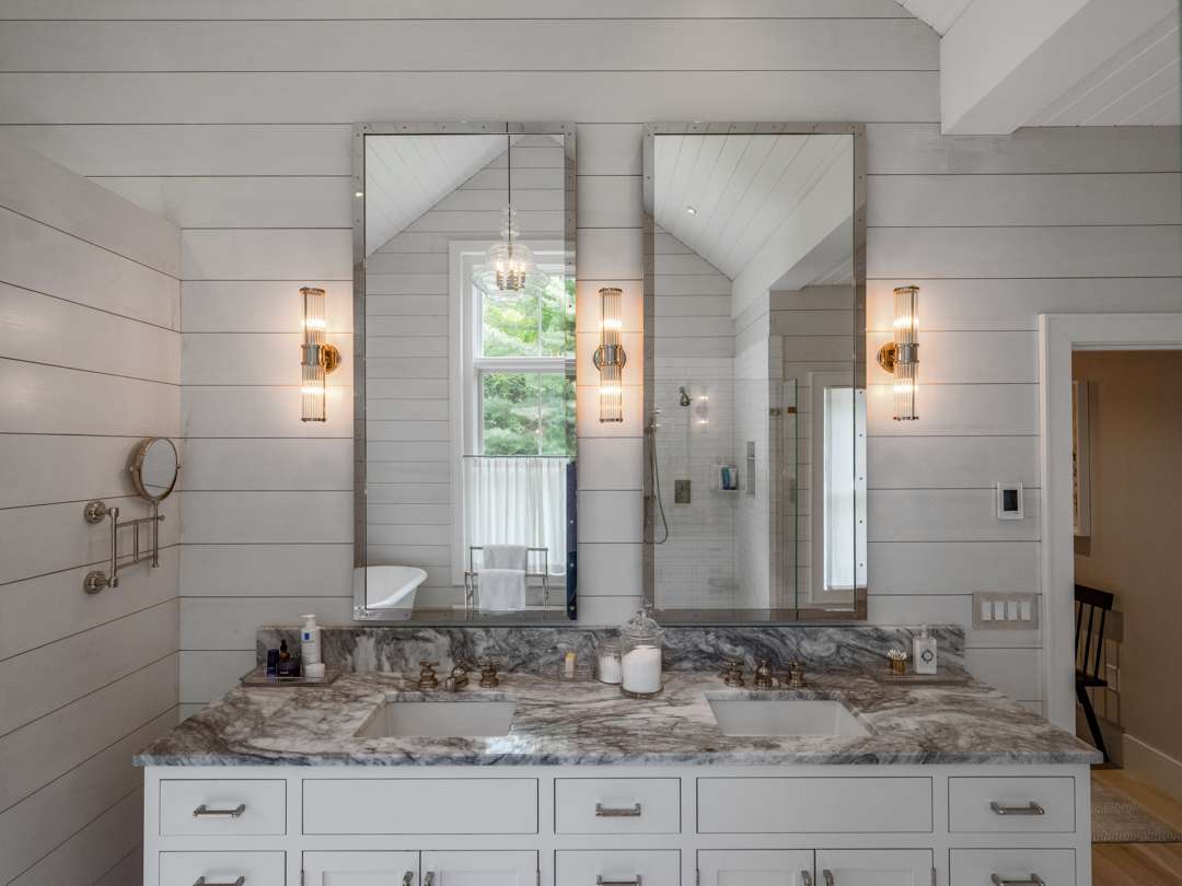 White bathroom with two sinks and marble countertops