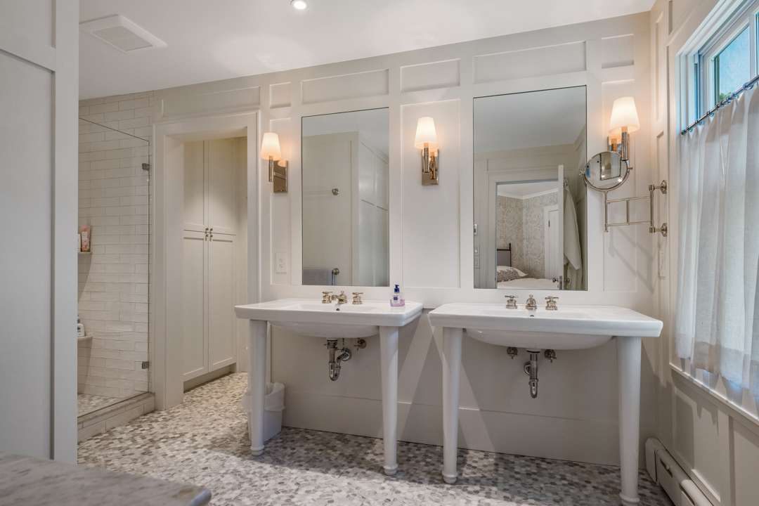White bathroom with two sinks and gray tile floor