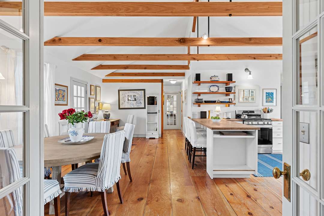 White kitchen and dining area with wood floors and blue accents