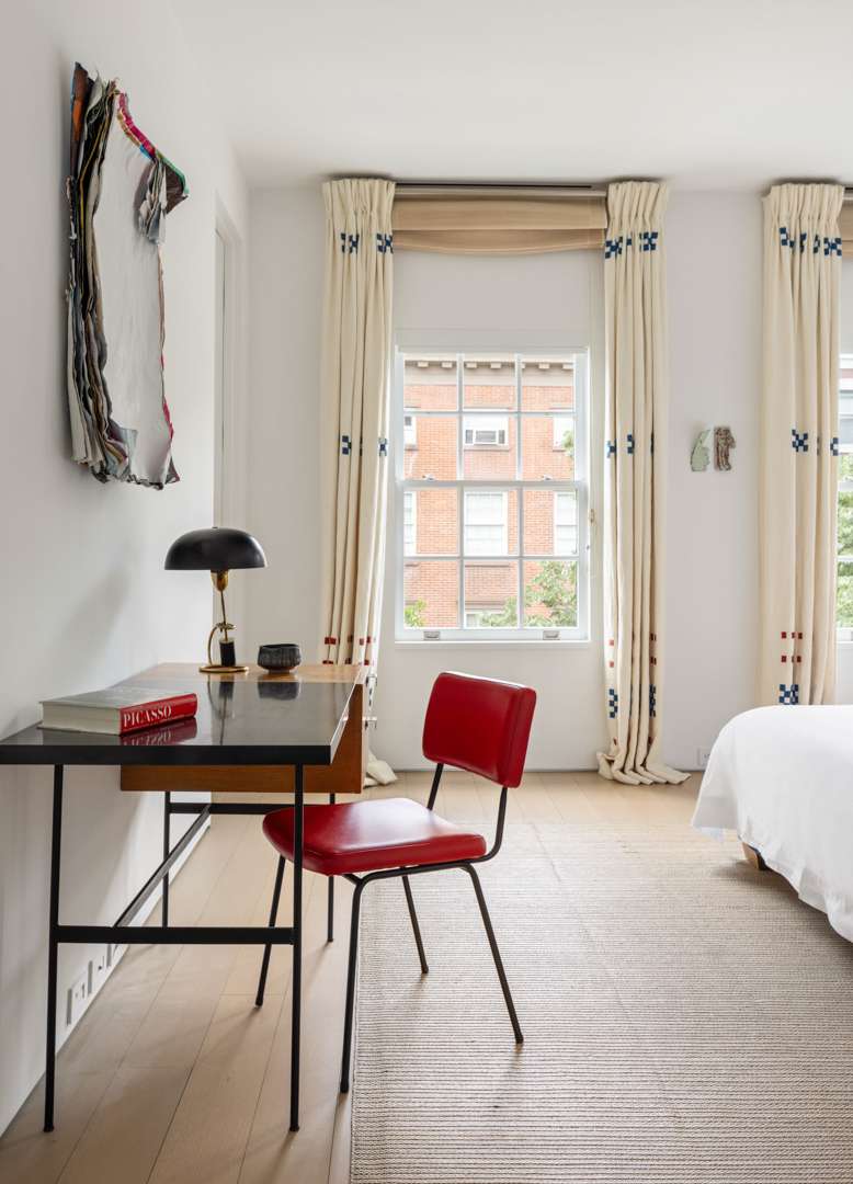 Black desk with red chair in white bedrooom