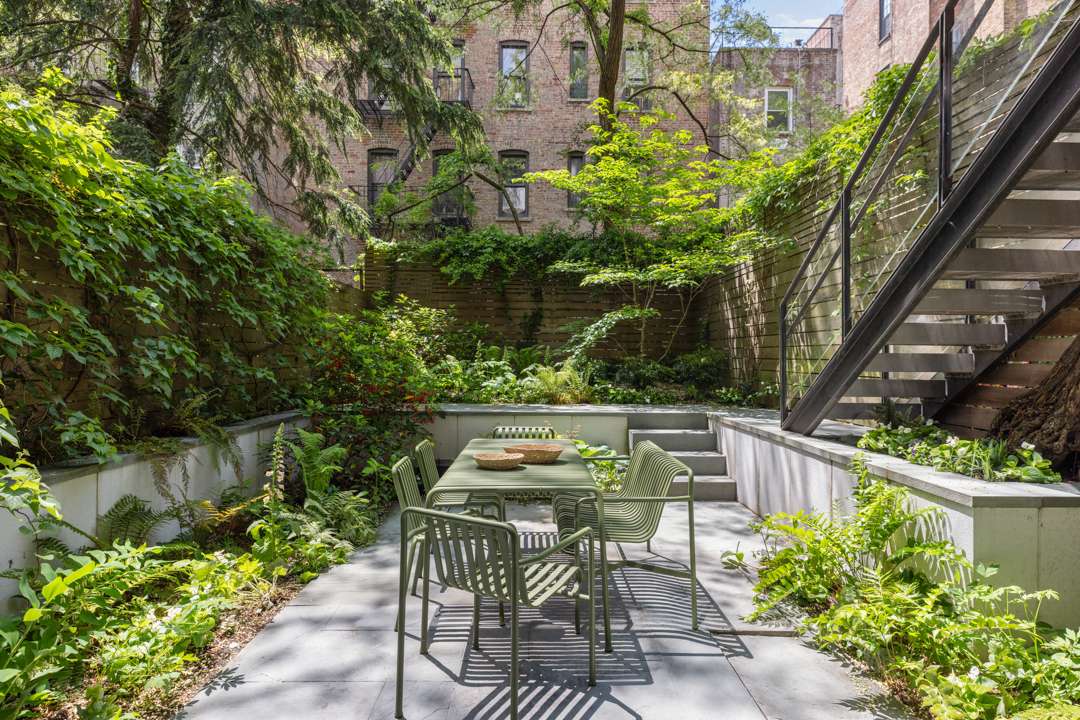 Private garden with sage green outdoor dining furniture