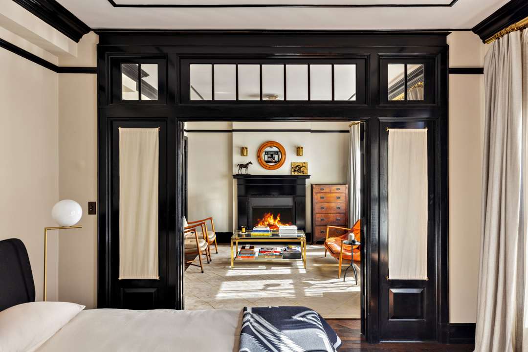 Bedroom with living room area with black fireplace