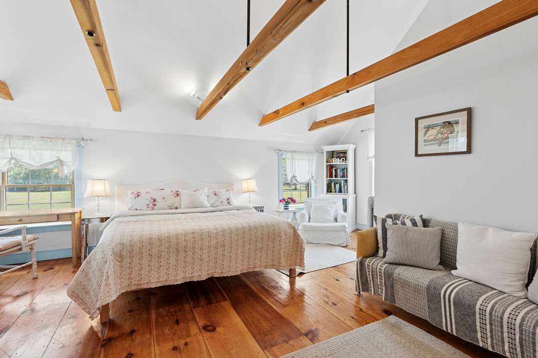 Bedroom with floral bedding and grey striped couch