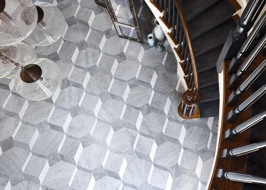 Black staircase leaving down to grey marble floors