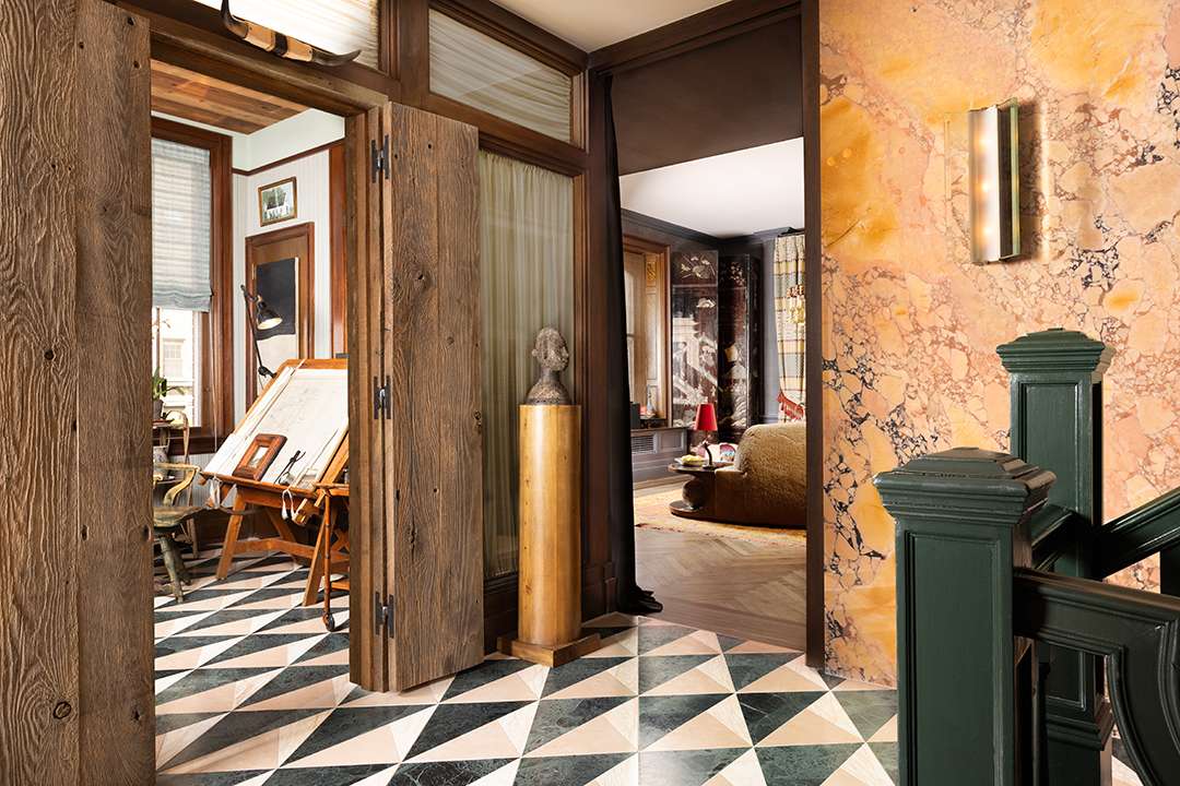 Foyer with marble walls and floors and wood doors and thresholds