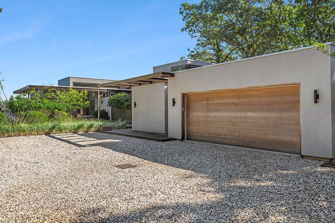 Gravel driveway with wood door garage