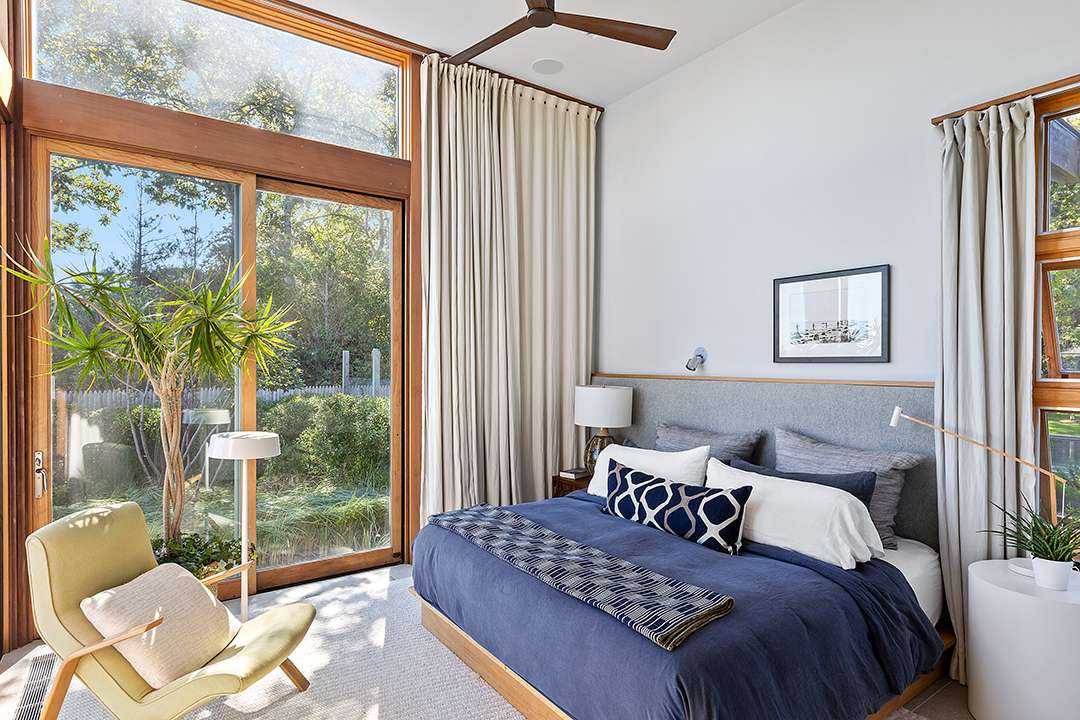 Bedroom with blue and white bedding and light green armchair