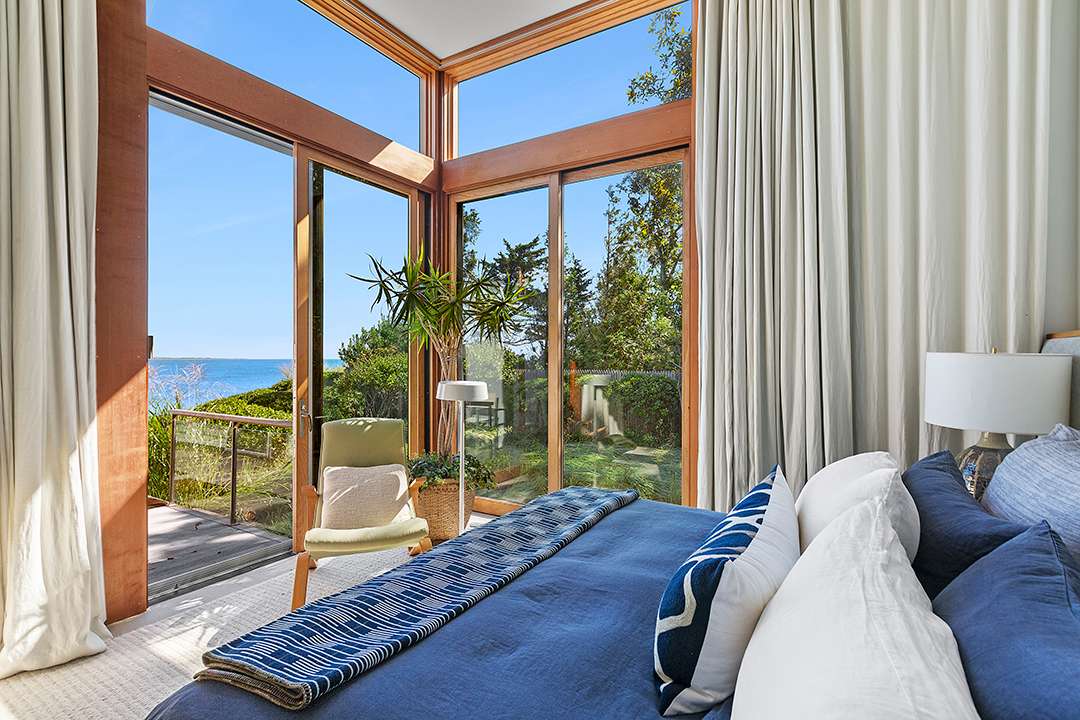Bedroom with blue and white bedding overlooking the bay