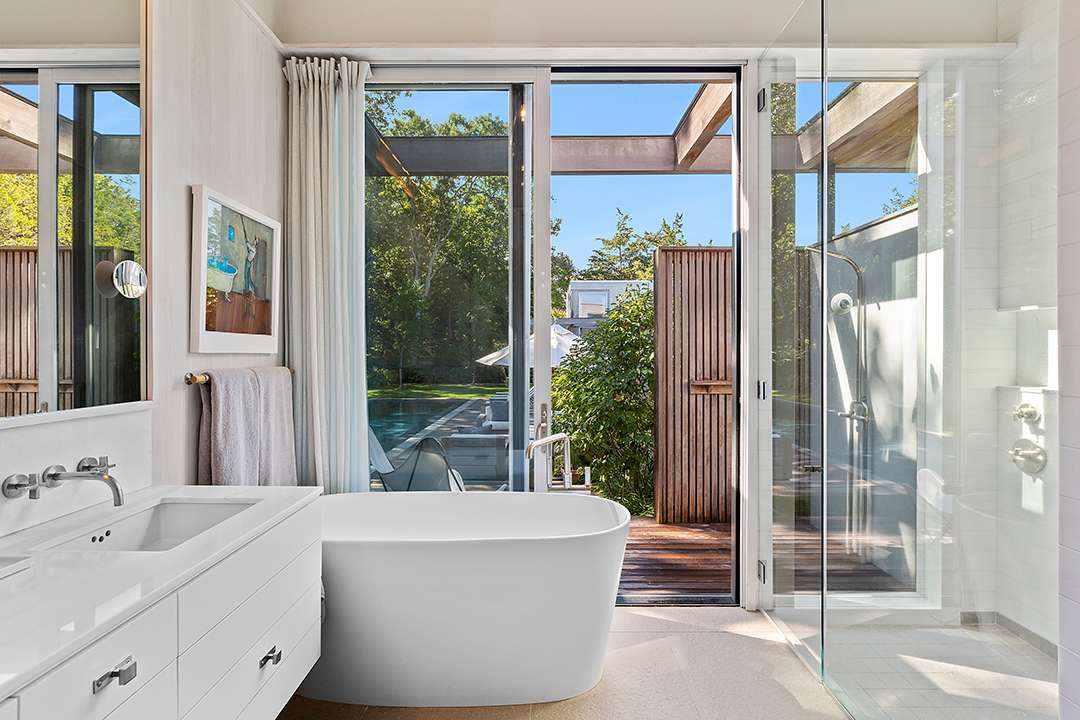 White bathroom with access to outdoor shower