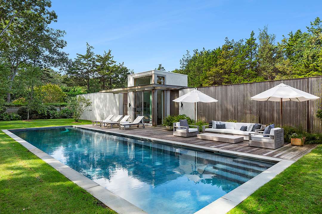 East Hampton pool with neutral seating area and chaise lounges