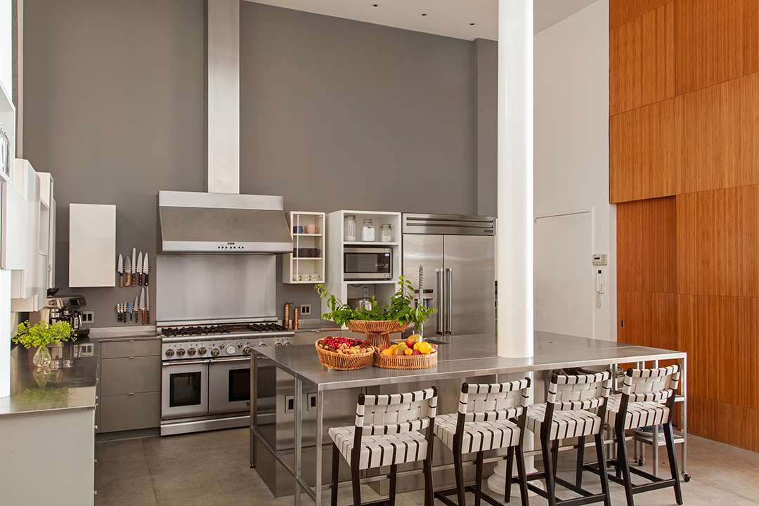 Grey kitchen with island with black and white barstools