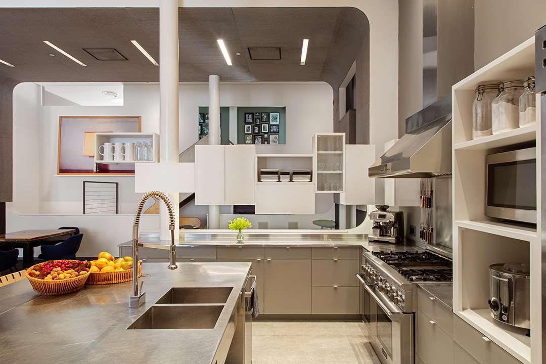 Kitchen with white cabinets, dark marble island, steel applicances