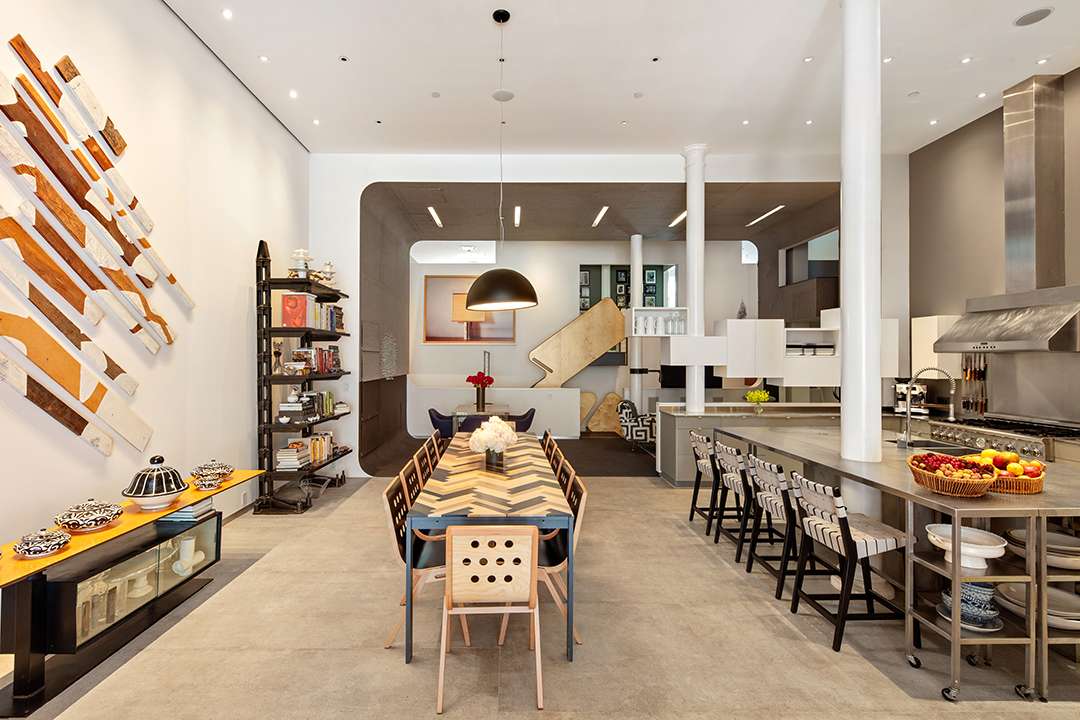 Kitchen with dining table, steel appliances, and island with seating