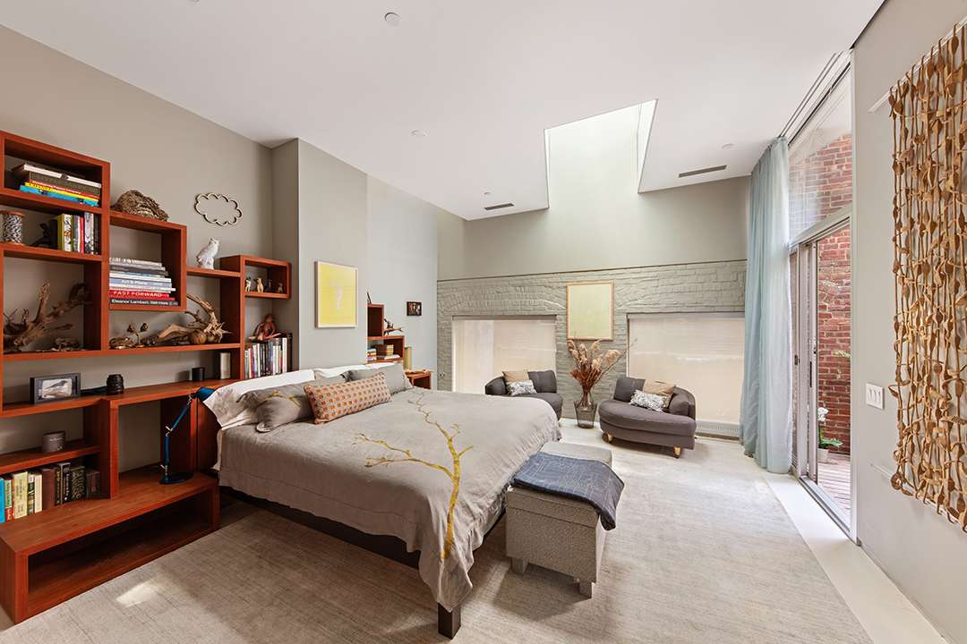Bedroom with wood built-in shelves and grey bedding with a gold tree