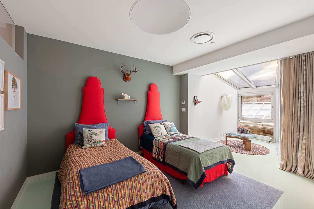 Playful bedroom with red headboard and colorful bedding