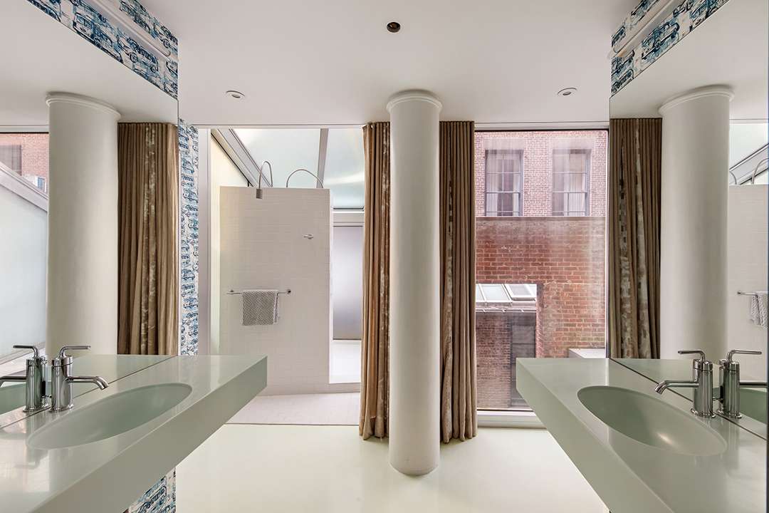 White and blue bathroom with bronze curtains and white pillars