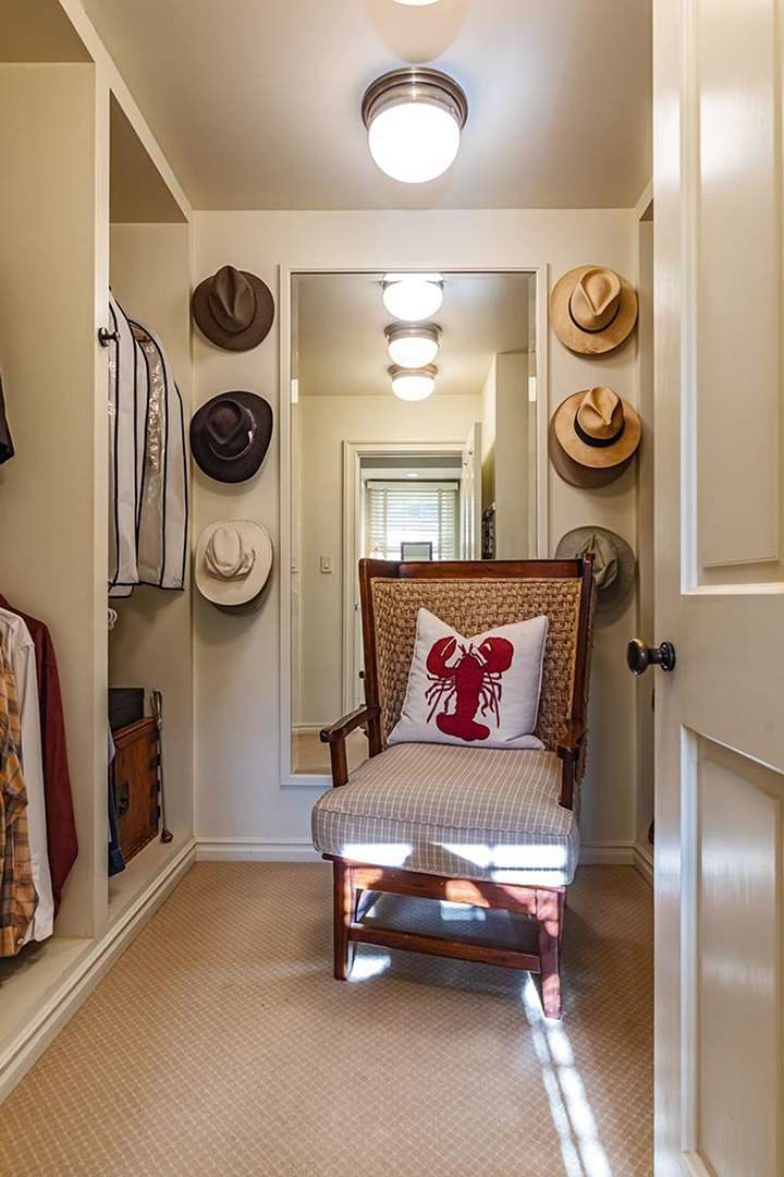 Closet with hats hanging and chair with lobster pillow at Audrey Hepburn's former LA mansion