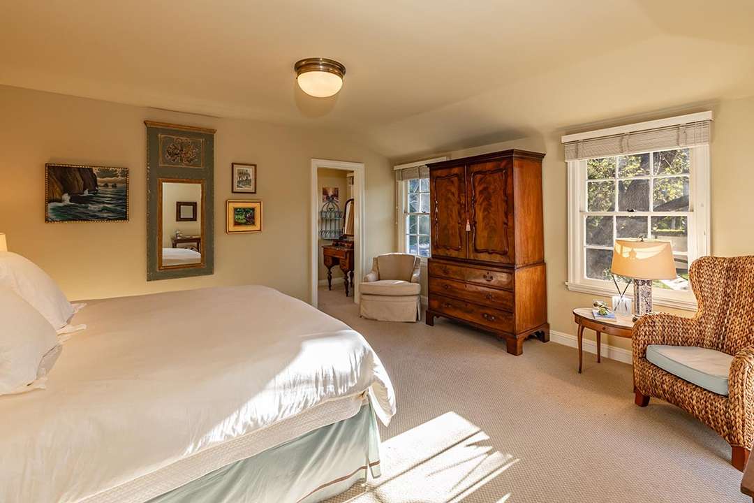 White and green bedroom with wood armoire at Audrey Hepburn's former LA mansion