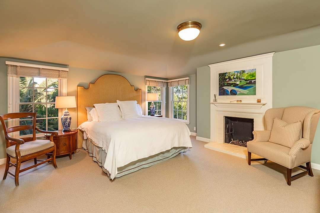 White and green bedroom with fire place at Audrey Hepburn's former LA mansion